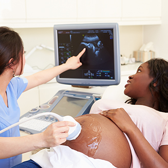 Médica fazendo ultrassom em mulher grávida