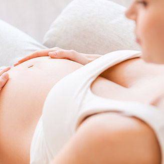 mulher grávida passando a mão na barriga 8º Curso para Gestantes