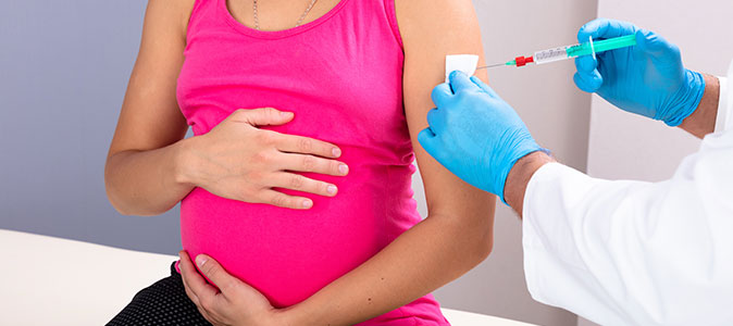 uma mulher grávida se vacina