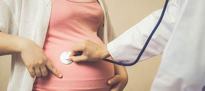 grávida se consultando com um médico