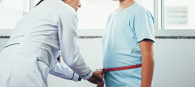um médica medindo um garoto