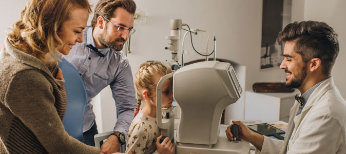pais e filha em uma consulta com o oftalmologista