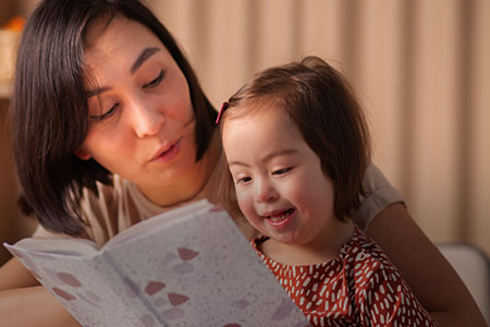 Uma mãe segurando um bebê que está lendo