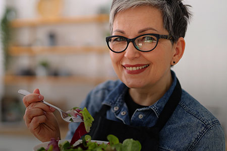Imagem de uma mulher com um prato de salada na mão