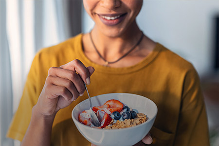 Foto de uma mulher sorrindo com um prato de comida