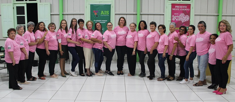 Integrantes do Amigas do Peito posam para fotos usando camisetas rosas
