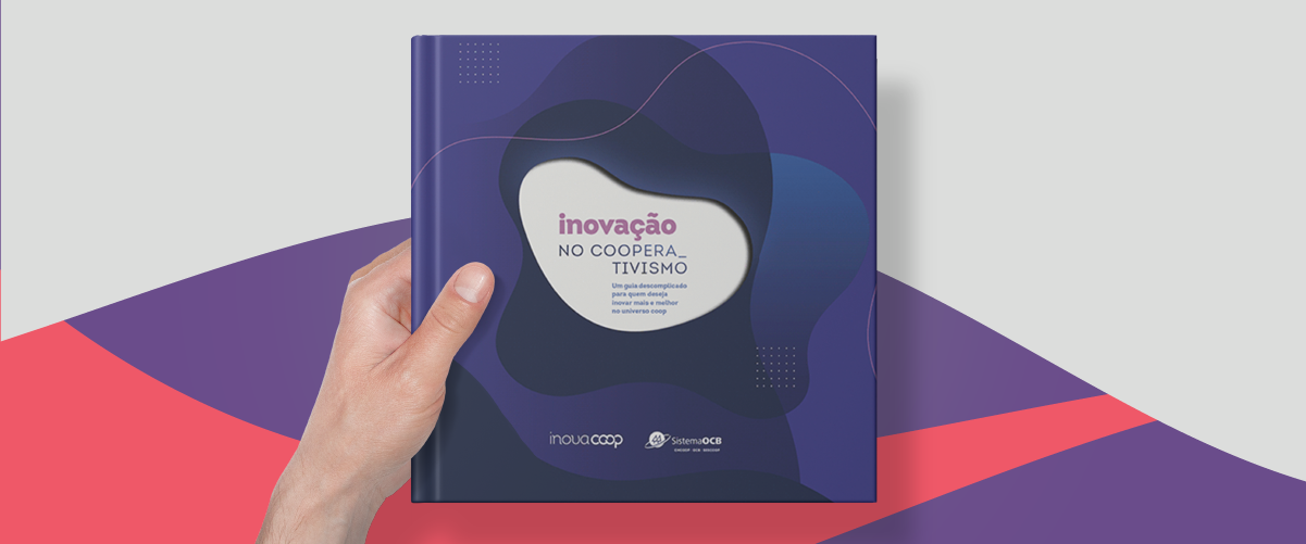 Mão masculina segura o livro da OCB, mostrando a capa em destaque