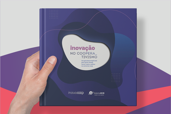 Mão masculina segura o livro da OCB, mostrando a capa em destaque